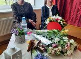 P.Žemgulienė po sveikinimų, daug gėlių ant stalo